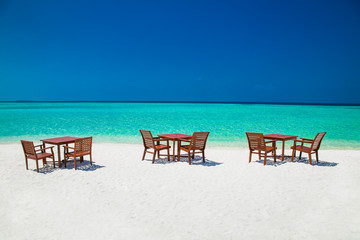 Table and chairs on tropical amazing vibrant beach in Maldives.