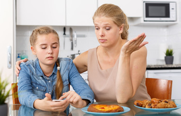 Woman outraged  looking into  phone of  daughter