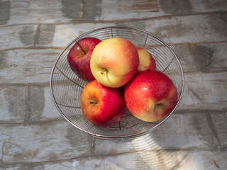 Ripe red apples in a metal basket