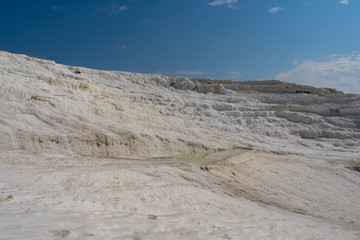 Sunny day in Pamukkale. Amazing white travertine, dry pool in Pamukkale, geological phenomenon, literally "Cotton Castle" in Turkish, most visited attraction in Turkey