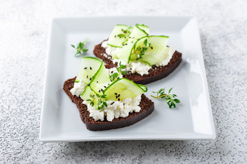 Toasts with ricotta, cucumber and black sesame