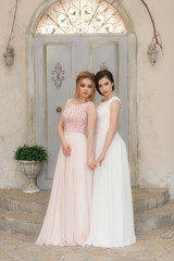 two brides white dresses looking forward. at old broken abandoned house door
