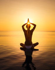 Woman has Yoga at infinity pool during sunset. Maldives