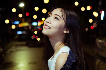 cute asian girl in the night light city with bokeh