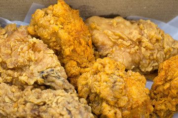 Close-up of fried chickens in cardboard box.