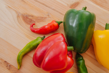 Close-up view of red, green, yellow and orange paprika and chili and group, tasty vegetable in a wood background in the kitchen.