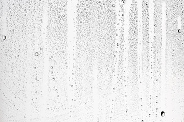 white isolated background water drops on the glass / wet window glass with splashes and drops of water and lime, texture autumn background