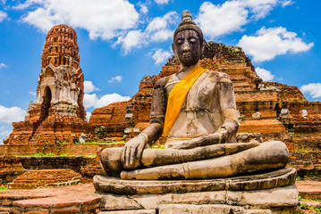 Thailand, Stupa and Buddha sculpture with orange sash in Ayutthaya old Temple
