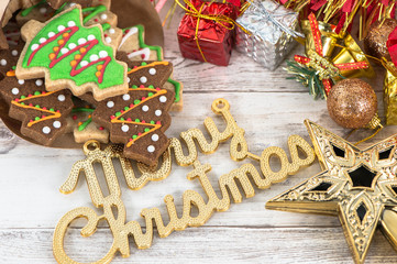 Beautiful Christmas composition and decoration with baked Christmas gingerbread cookie in paper bag on light wooden background, flat lay, top view, copy space (text space)