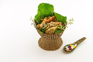 Assorted of herbal in brown bamboo basket  and colorful pills in wooden spoon isolate on white background