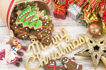 Beautiful Christmas composition and decoration with baked Christmas gingerbread cookie in paper bag on light wooden background, flat lay, top view, copy space (text space)