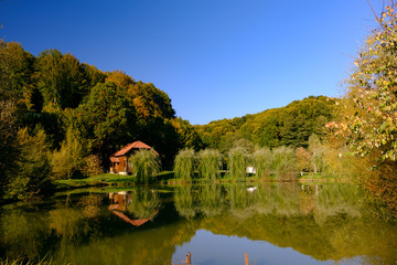 Fototapeta na wymiar Mountain house over a lake autumn landscape