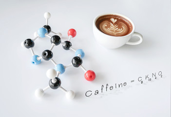 Coffee cup of cappuccino with latte art and molecule of caffeine structure on white table