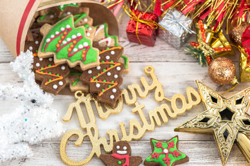 Beautiful Christmas composition and decoration with baked Christmas gingerbread cookie in paper bag on light wooden background, flat lay, top view, copy space (text space)