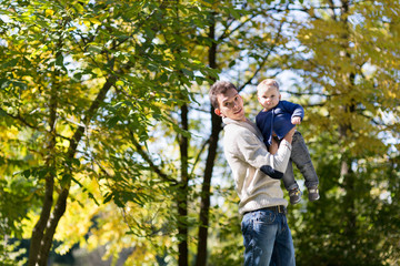 Naklejka na ściany i meble dad with baby in autumn park