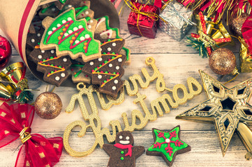 Beautiful Christmas composition and decoration with baked Christmas gingerbread cookie in paper bag on light wooden background, flat lay, top view, copy space (text space)