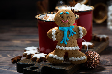 gingerbread man cookies and hot chocolate on wooden background