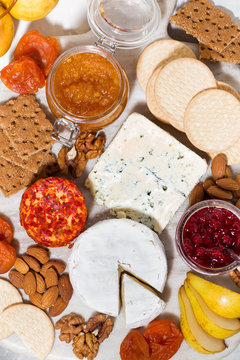 assortment of snacks with cheeses, fruits and nuts, top view vertical