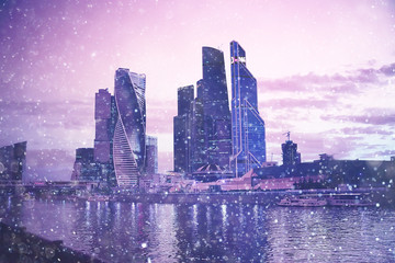 snow in a night city skyscrapers / seasonal landscape winter city, snowfall against a background of...