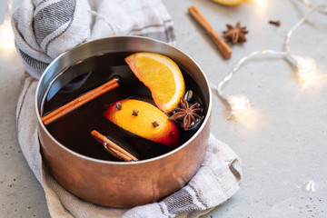 Mulled wine hot drink with oranges and spices in copper pot