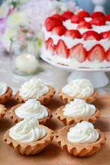 Cupcakes and strawberry cake on cake stand.