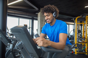 Fototapeta na wymiar Handsome young african american man cycling at the gym
