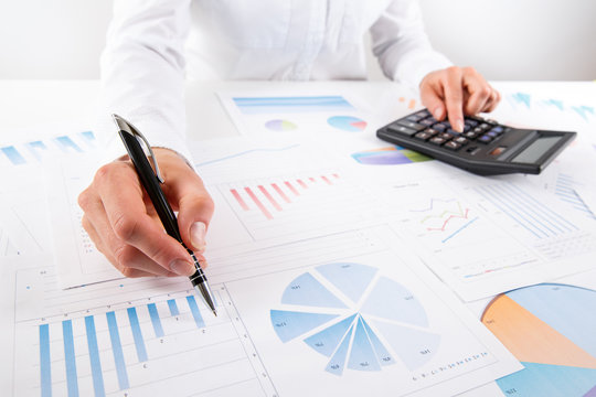 Business woman pointing at graph document close-up.