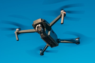 Flying drone or quadcopter with camera at blue sky background