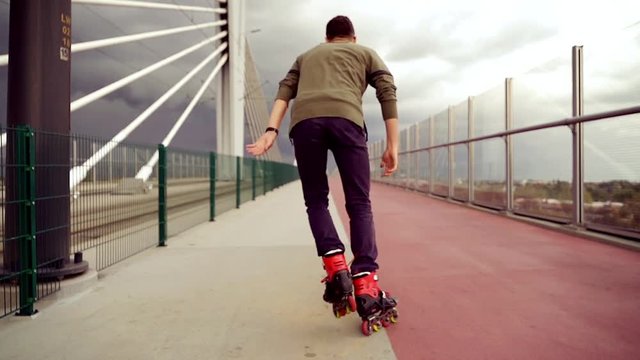 Young man in rollerblades riding in the city, super slow motion 
