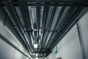Industrial heating pipes under celling or another household communications pipelines in modern building