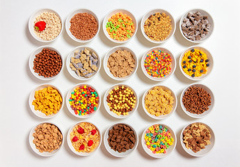 set of different cereals on a white background. 20 bowls with cornflakes, kasha, cereals and berries. the concept of breakfast food. flat lay, top view