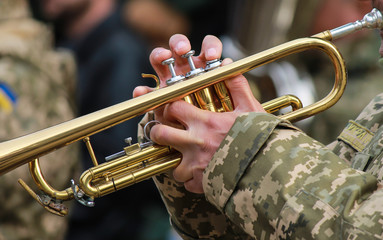 Musician military band of the Ukrainian army plays the trumpet on the march, the Armed Forces of...