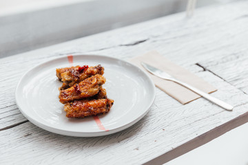 Korean Chicken Wings stir with Korean style sauce served in white plate. 