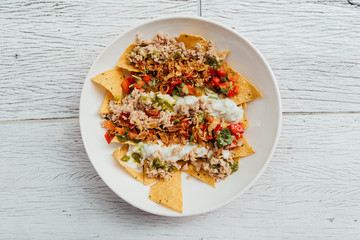 Fusion food: Top view of Soboro Chicken Nachos: Japanese-style stir-fried chicken with tomato salsa, yogurt and Thai-style seafood sauce.