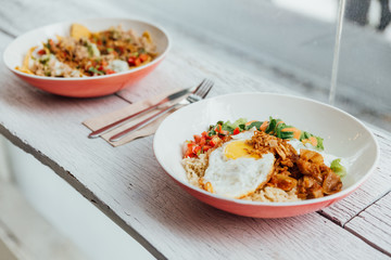 Fusion food Rice bowl toppings kimchi pork, organic fried egg, Korean eggplant and salad.