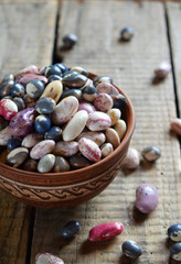 Assortment of young legumes and beans of different varieties and colors in a clay bowl. Raw food. Healthy diet concept. Selective focus
