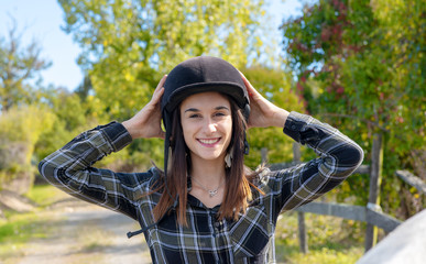 Portrait of a happy female jockey with helmet