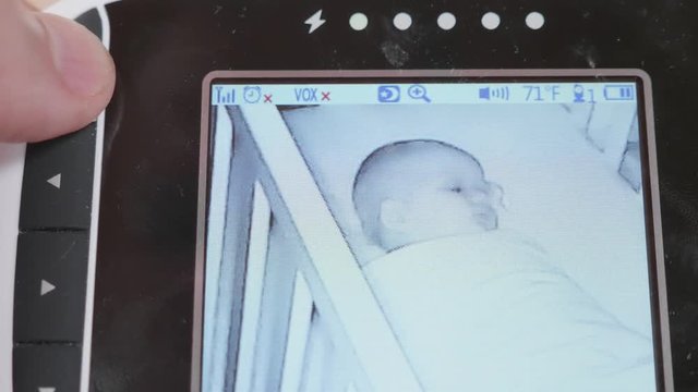 Mother Watching Her Newborn Baby Girl Through Baby Monitor