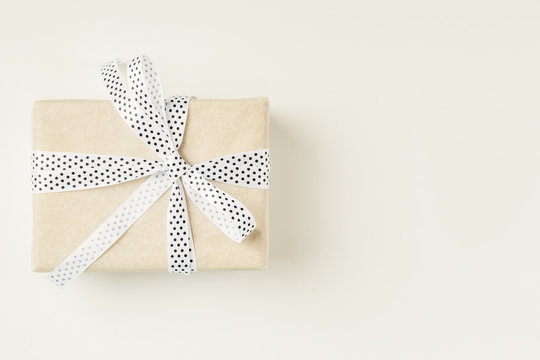 Wrapped Gift Box With Ribbon Bow On A White Background, Copy Space