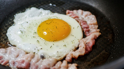 Cooking eggs with bacon and greens