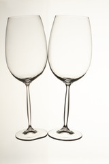 Two empty glass cups lying horizontally. Isolated white background.