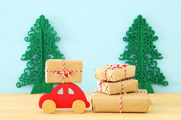 Obraz na płótnie Canvas Wooden red car carrying a christmas gift.