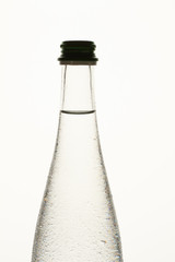 Transparent bottle with dew. Close up. Bottleenck with cap, white isolated background.