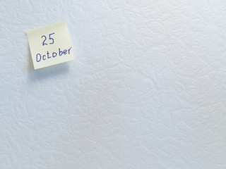 October 25. Calendar date on a yellow sticky note with copy space on white background.