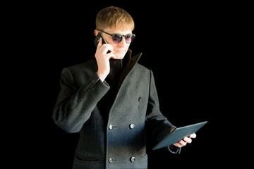 Obraz premium Portrait of a confident businessman in a coat talking on the phone