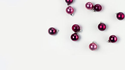 Christmas flat lay scene with pink abd violet glass balls on white background