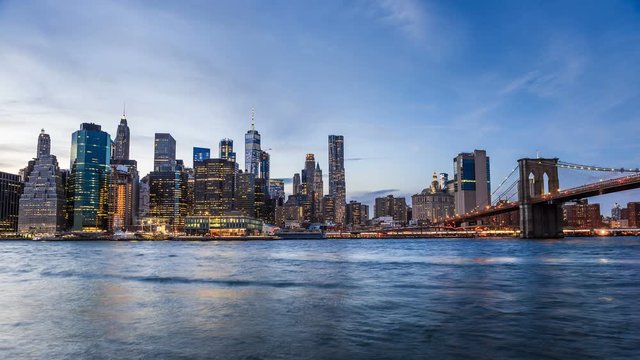 4k cinemagraph of New York City Manhattan, financial district skyline, cityscape at Brooklyn bridge park during sunset, dusk, night, twilight, skyscrapers, moving traffic, cars, light streaks