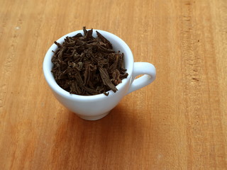 A cup of dry tea. Black tea. A cup of tea.
