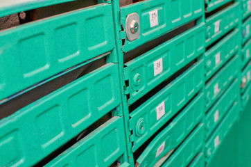 Many green post boxes with numbers