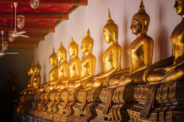 A row of Buddha images inside Thai Buddhist Temple